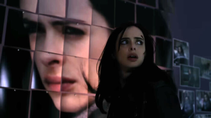 Female character looking anxious in a dark setting with a large emotional face image in the background, representing well-written characters.