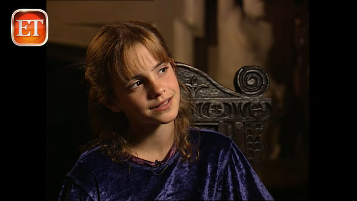 Young woman in a velvet top seated on an ornate chair, reflecting on unexplained mysteries from the dawn of the internet.