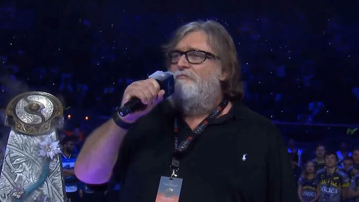 Man with glasses and beard holding microphone at event, illustrating real-life stories of people becoming what they once hated.