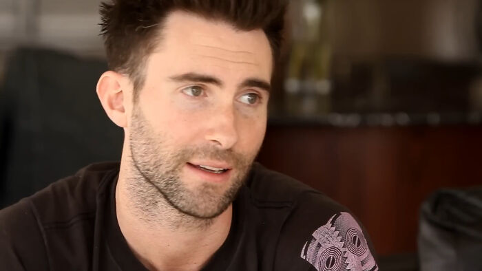 Man sharing sounds while looking away, expressing emotions in a casual indoor setting focused on people sharing sounds.