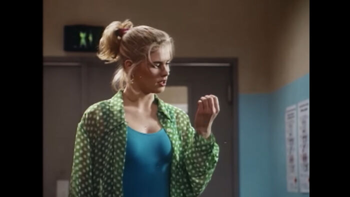 Young woman in a green polka dot shirt looks puzzled, representing unexplained mysteries from the dawn of the internet.