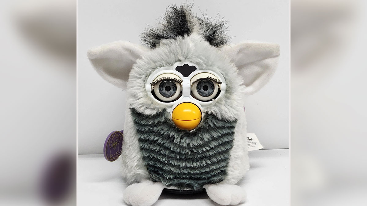 Vintage toys worth fortune featuring a classic Furby toy with fluffy fur and large eyes on a white surface.