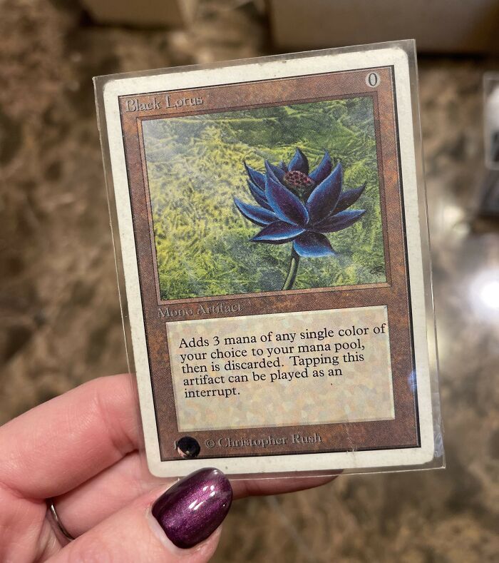 Hand holding a vintage collectible Magic The Gathering Black Lotus card, a vintage toy worth a fortune in mint condition.