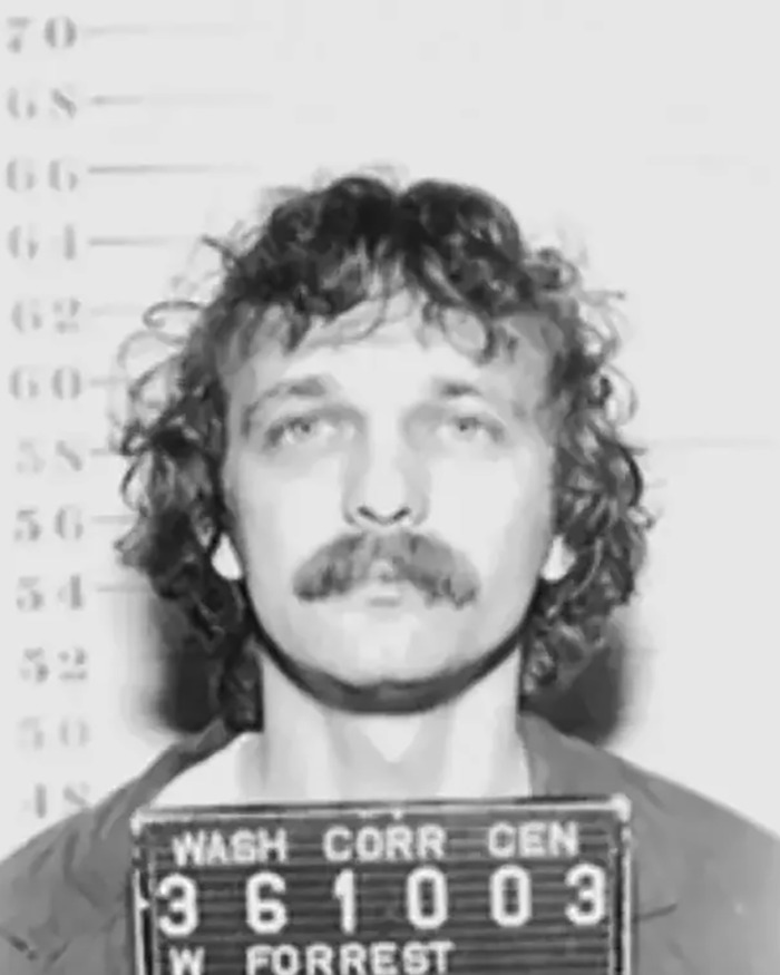 Mugshot of a man with curly hair and mustache against height chart related to teen survival story in homicide spree.