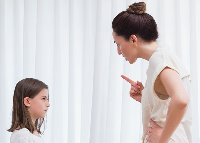 Woman scolding girl at home, illustrating wildest rules people grew up with that still confuse them today.