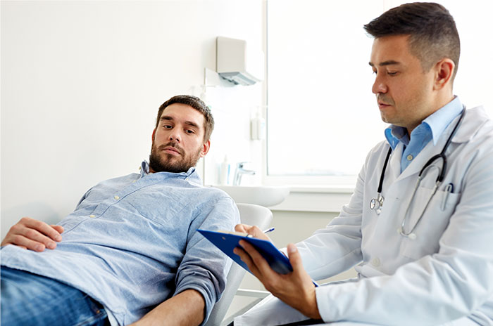 Patient lying on exam table talking to doctor holding clipboard in a medical office, illustrating patients trying to fool doctors.