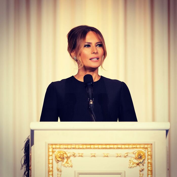 Melania Trump speaking at a podium during the state visit, explaining why she didn't curtsy to the British royals. Melania Trump speaking at a podium during the state visit, explaining why she didn't curtsy to the British royals.
