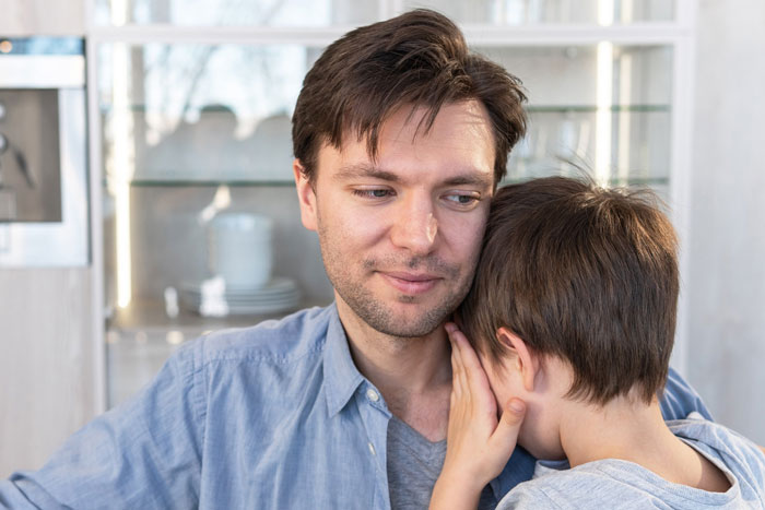 Man comforting young boy who appears upset, illustrating emotional impact of wife turned mean once got money situation.