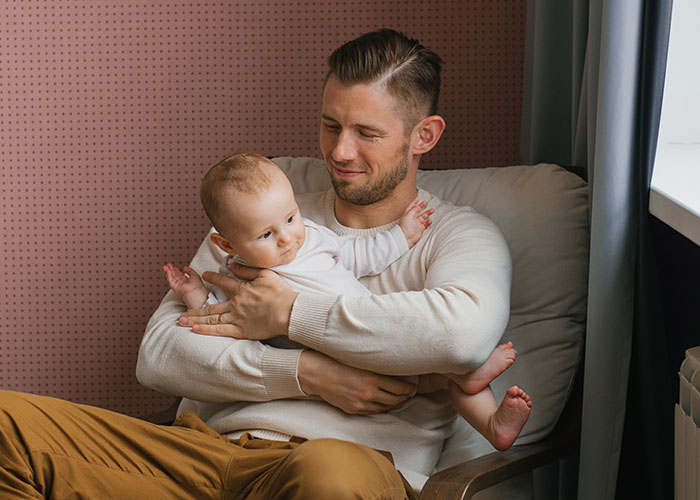 Father holding baby in nursery with a concerned expression, highlighting a family issue and planning an exit strategy. Father holding baby in nursery with a concerned expression, highlighting a family issue and planning an exit strategy.