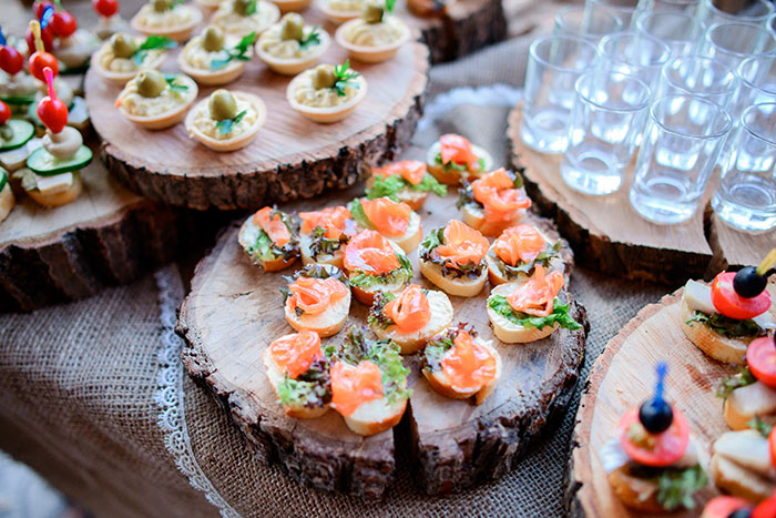 Assorted wedding appetizers on wooden platters showcasing food that challenges accommodating a friend&rsquo;s diet.