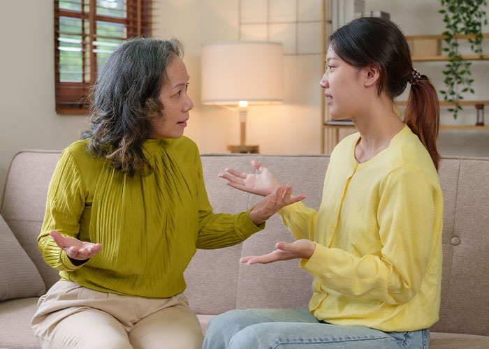 Woman and older female relative having a serious conversation in living room, woman forbids BIL from talking to her.