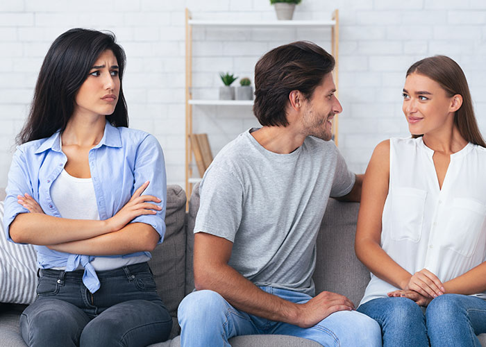 Woman forbids BIL from talking to her, looking upset while man and another woman smile, showing family tension at home.