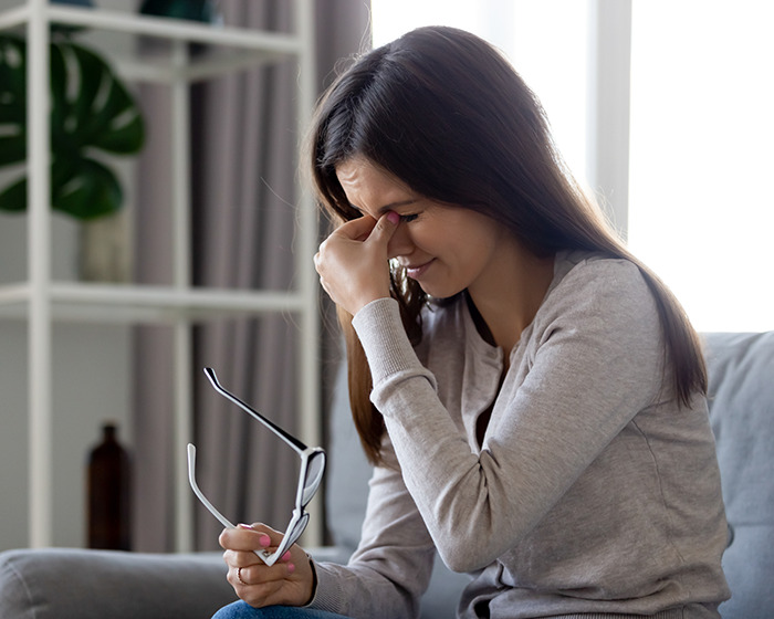 Woman holding glasses and rubbing eyes, showing relief after solving a medical mystery for a friend quickly. Woman holding glasses and rubbing eyes, showing relief after solving a medical mystery for a friend quickly.