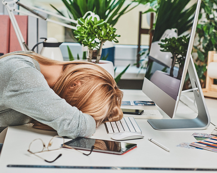 Woman solving friend’s medical mystery leaning on desk with computer and office supplies in bright workspace. Woman solving friend’s medical mystery leaning on desk with computer and office supplies in bright workspace.