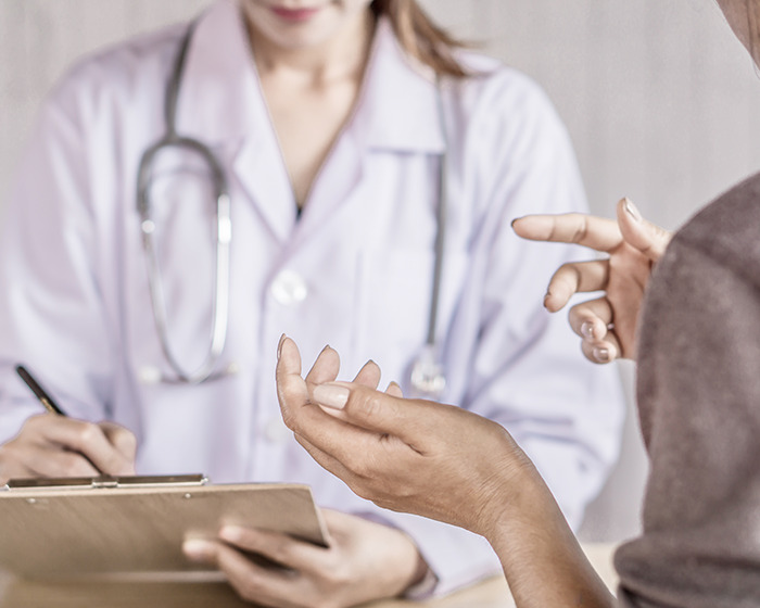 Woman consulting a doctor discussing medical mystery after multiple doctors failed to diagnose the condition. Woman consulting a doctor discussing medical mystery after multiple doctors failed to diagnose the condition.