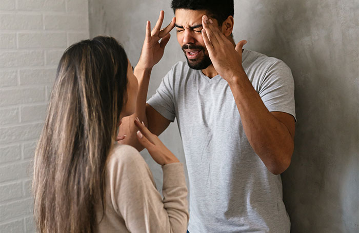 Stressed young man and woman arguing indoors, depicting tension related to student kicked out for roommate's Muslim mom appearances. Stressed young man and woman arguing indoors, depicting tension related to student kicked out for roommate's Muslim mom appearances.