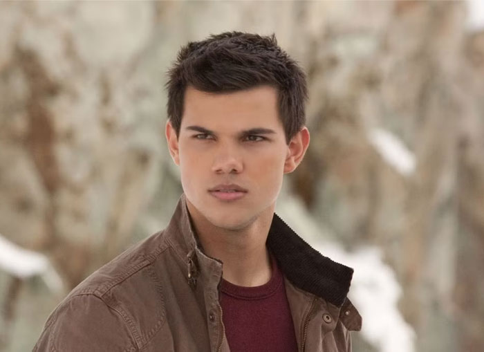 Young man in a brown jacket with a serious expression outdoors, illustrating rage-baits that can ruin a man’s day.