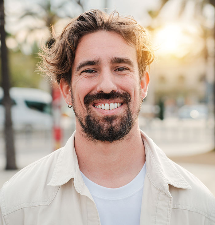 Smiling man outdoors in casual clothing, representing rage-baits from women who know exactly what to say to ruin a man’s day.