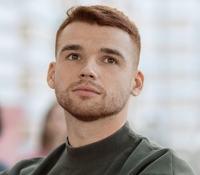 Young man with thoughtful expression, illustrating emotions related to rage-baits that can ruin a man's day.
