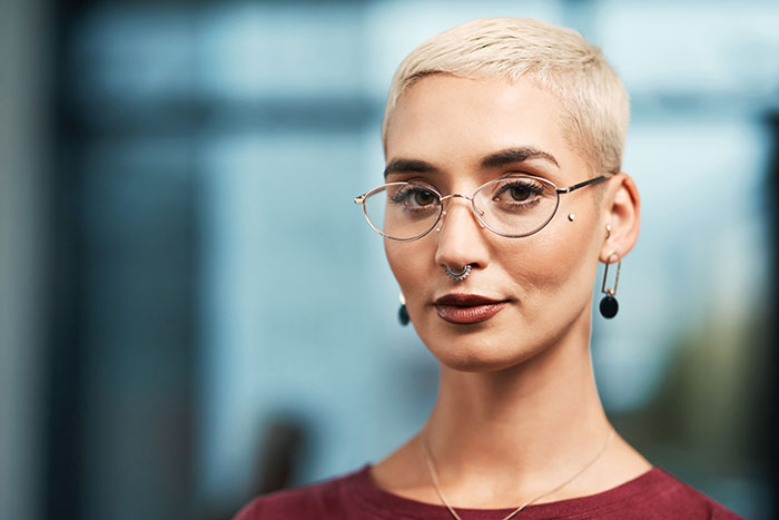 Confident woman with short blonde hair and glasses, showcasing rage-baits from women who know what to say.