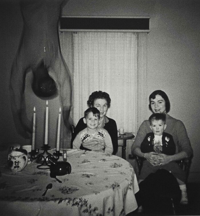 Black and white vintage family photo with a mysterious upside-down figure, capturing strange and unexplained histories.