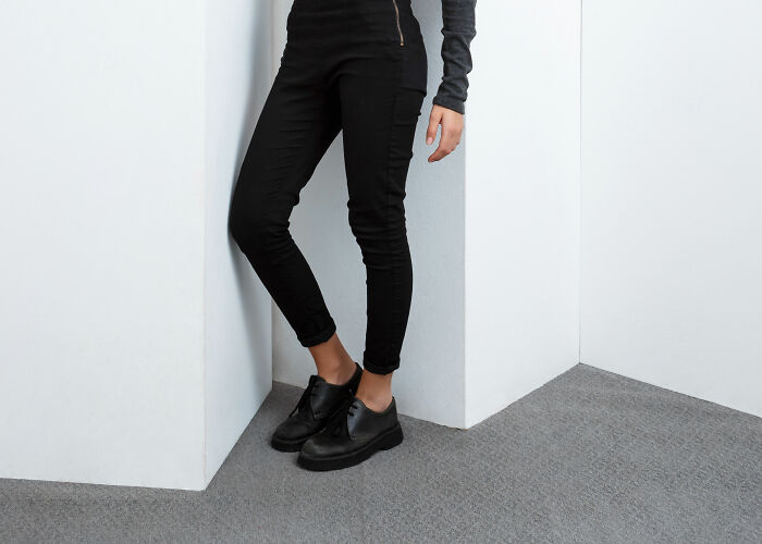 Person wearing black pants and shoes standing in a corner representing wildest rules people grew up with.