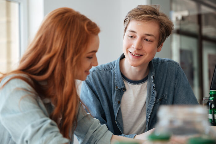 A young woman and man on a date smiling and talking, illustrating tests women use to spot red flags.