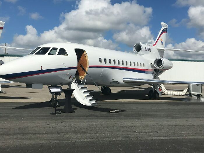 Private jet parked on tarmac with stairs deployed, illustrating jobs serving ultra-wealthy people and their luxury needs.