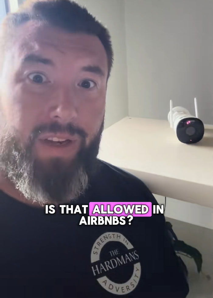 Man with beard in rental house reacting to disturbing discovery near security camera after family rushes out following discovery