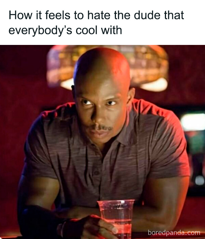 Man in a bar looking serious with a drink, representing a funny and relatable TV meme about awkward social feelings.