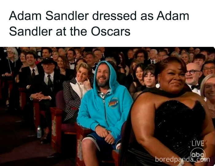 Audience laughing at Adam Sandler dressed casually in a hoodie at a formal awards show in a funny TV meme.