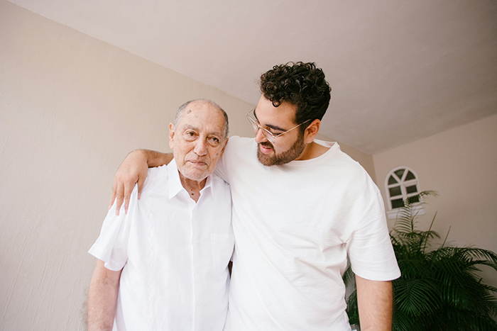 Young man with arm around older man, representing family dynamics and controlling sibling behavior involving golden child concept.