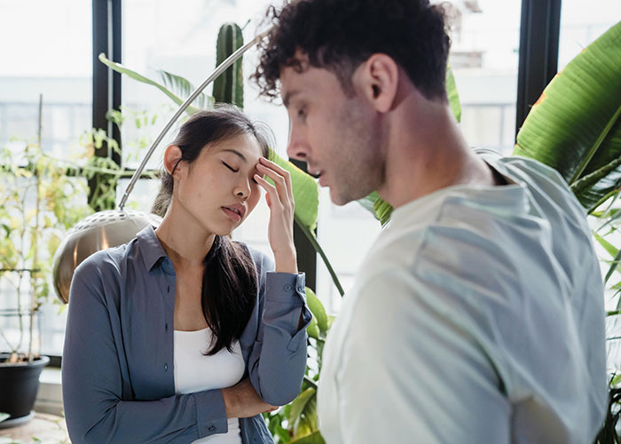 Man and woman in a tense discussion indoors, representing a man prepared to fight for stepson's diet change against mom's wishes.