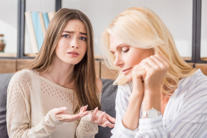 Young woman expressing frustration while talking to her mother about food allergies and no contact situation.