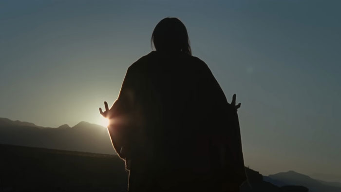 Silhouette of a figure with outstretched arms at sunset in a desert setting, related to Nicolas Cage horror film role. Silhouette of a figure with outstretched arms at sunset in a desert setting, related to Nicolas Cage horror film role.