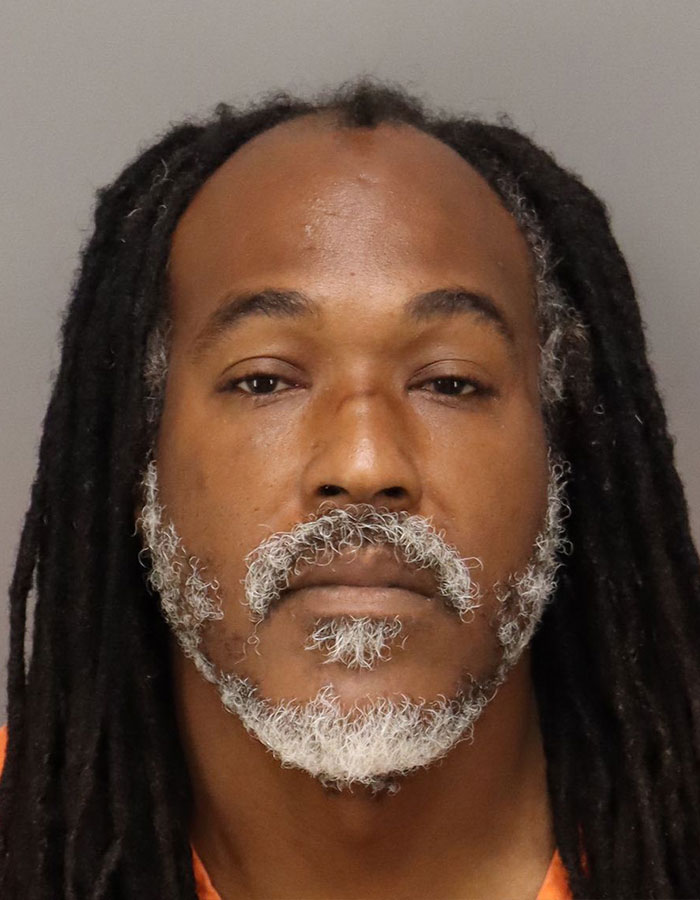 Mugshot of a man with dreadlocks and gray beard related to pit bull incident protecting 15-year-old girl from attacker.