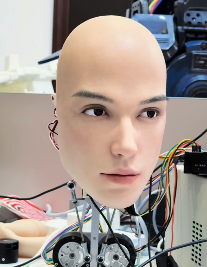 Human-like robot head with realistic facial features and wires, sparking debate about technology going too far in robotics.