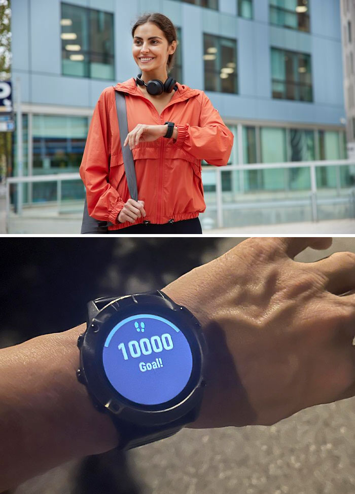 Young woman in urban setting checking smartwatch showing 10,000 steps goal completed, emphasizing healthy habits.