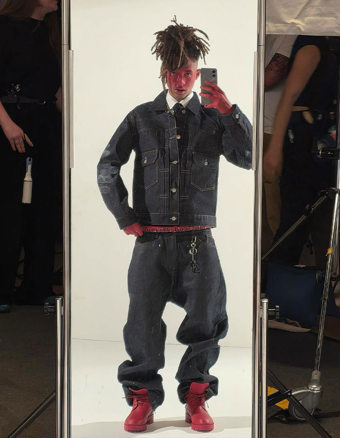 Jaden Smith with red face and casual denim outfit, posing in front of a mirror during Paris photoshoot. Jaden Smith with red face and casual denim outfit, posing in front of a mirror during Paris photoshoot.