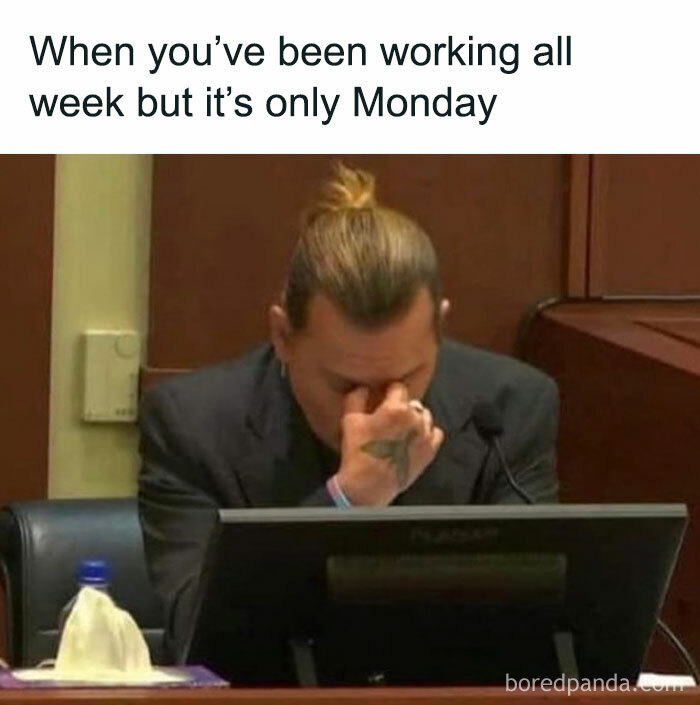 Man in a suit stressed at his desk, illustrating a relatable work meme about feeling overwhelmed early in the workweek.
