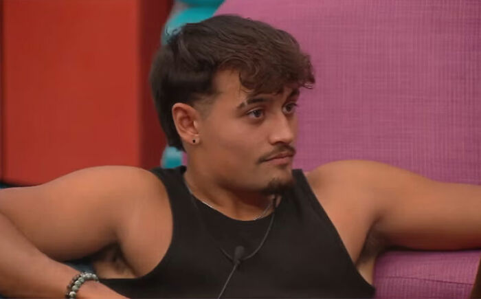 A Big Brother housemate sitting on a couch looking tense during one of the most uncomfortable moments in 23 years.
