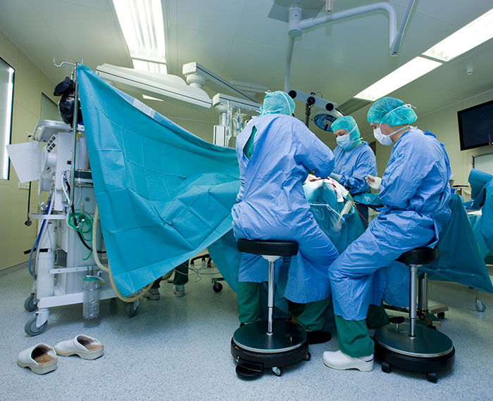 Brain surgeon and surgical team performing a complex procedure in a sterile operating room environment.