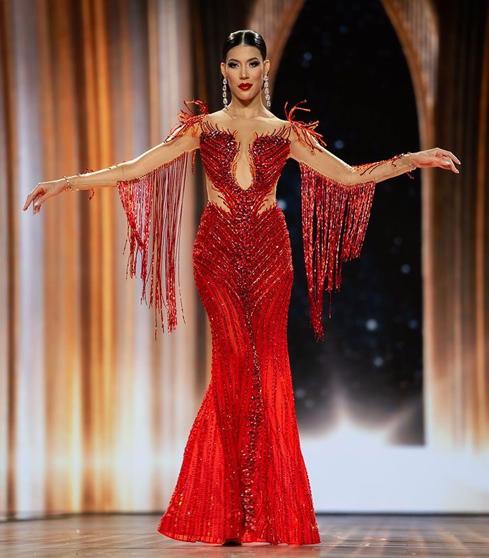 Miss Panama wearing an elaborate red gown with fringe details, posing onstage during a beauty pageant event.