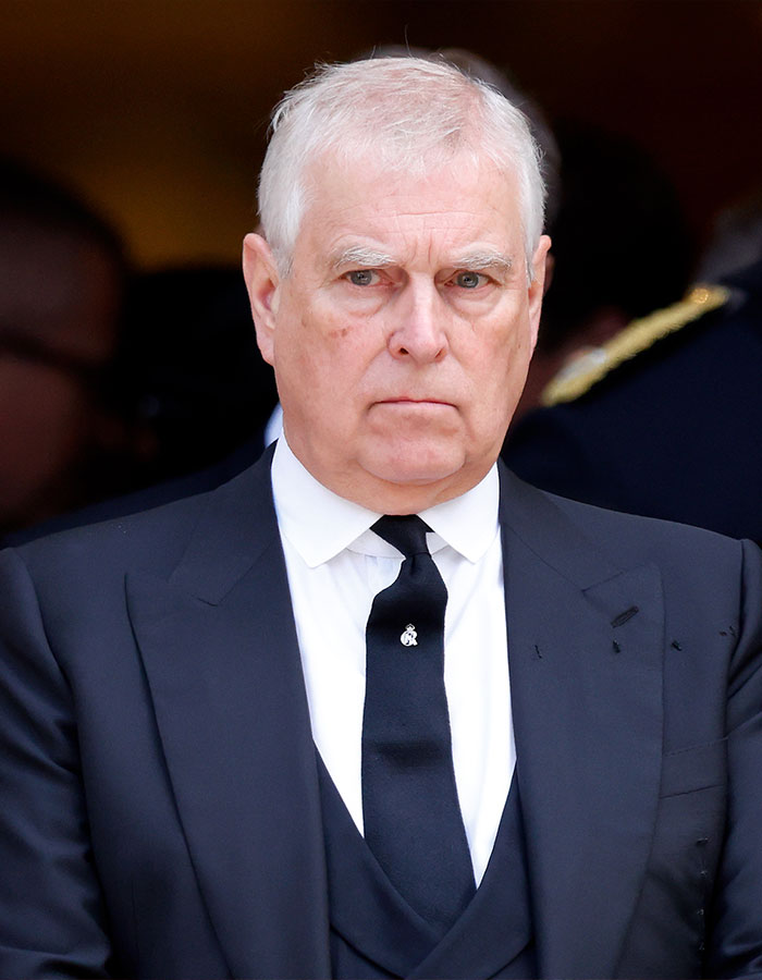 Prince Andrew in a formal black suit and tie, looking serious amid new allegations linked to Virginia Giuffre's memoir.