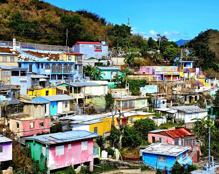 Colorful houses on a hillside in a neglected area, representing one of the places people wouldn’t revisit even if paid.