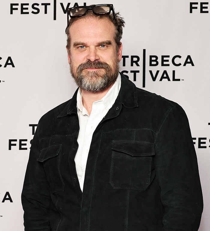 David Harbour at Tribeca Festival wearing a black jacket and white shirt, related to viral interaction with woman half his age.