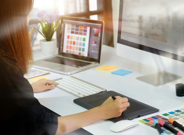 Person working at a computer with design software, illustrating company claims about market changes and salary raises.