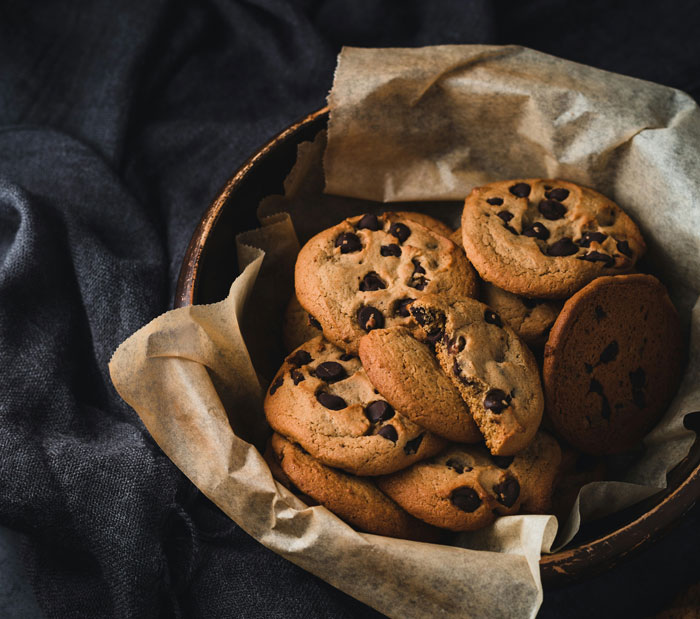 Bowl of chocolate chip cookies on parchment paper, symbolizing comfort for people who endured narcissistic mothers.