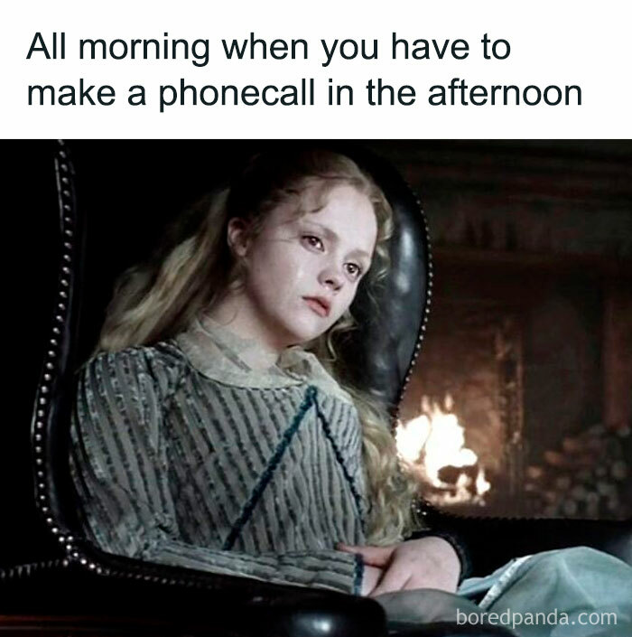 Young woman with pale face sitting in a chair by a fireplace, expressing boredom in a hilarious horror movie meme.