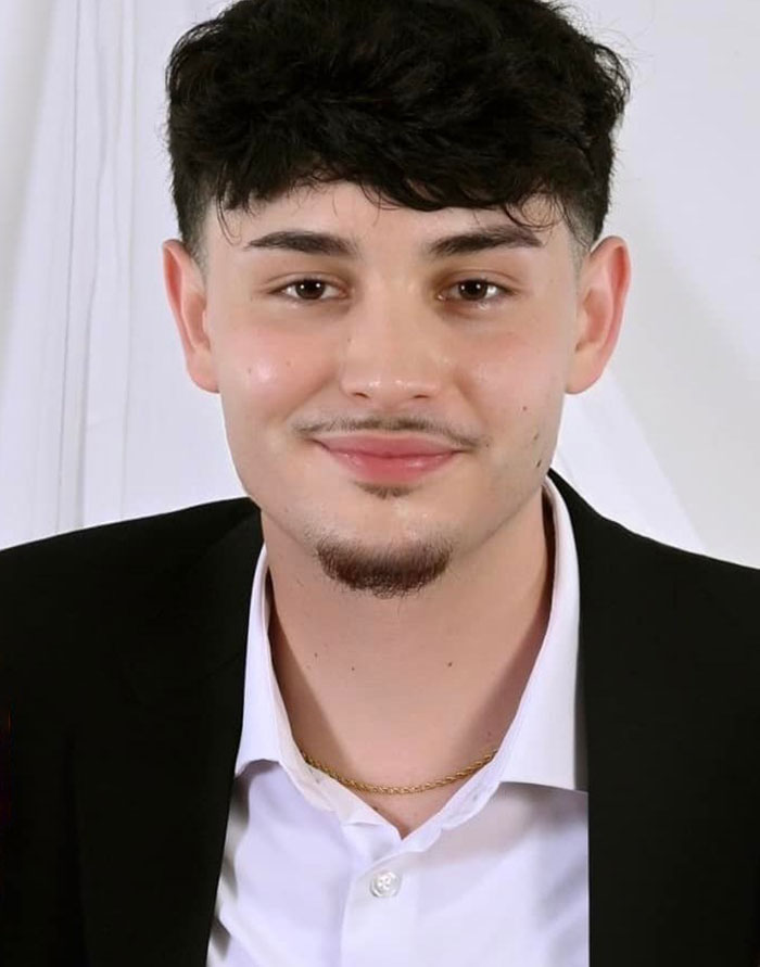 Young Florida dad-to-be with dark hair and goatee, wearing a black jacket and white shirt, smiling softly at the camera. Young Florida dad-to-be with dark hair and goatee, wearing a black jacket and white shirt, smiling softly at the camera.